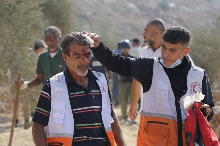 Paramedics provide first aid to Palestinian farmers, journalists and foreign activists injured after an attack by illegal settlers, covering their faces with masks, in Beita town of Nablus, West Bank on November 08, 2025. (Photo by Nedal Eshtayah/Anadolu via Getty Images)