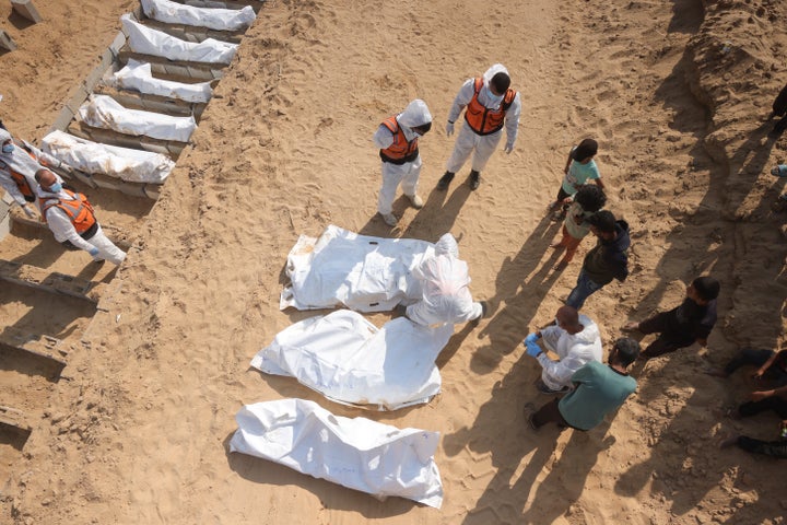 Health and civilian workers prepare a mass grave for slain Palestinians at a cemetery in southern Gaza's Khan Younis, on Nov. 10, 2025. The Gaza Health Ministry said it received the bodies of 15 Palestinian hostages that day from Israel, as part of the ceasefire's first phase.