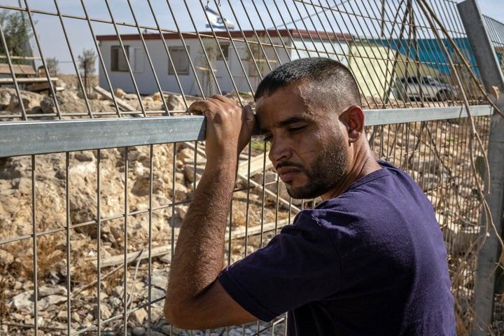 Palestinian community leader Khalil Hathaleen, whose brother Awdah was shot dead this year by an Israeli settler, stands on the fence that separates the Umm al-Khair village from an Israeli settlement in the occupied West Bank, on Nov. 2, 2025. Like other nearby communities, the village's roughly 200 residents descend from Bedouins who were expelled from the Negev desert during the 1948 war surrounding the state of Israel’s creation.