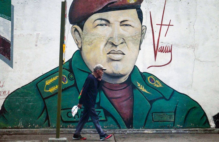 A man walks past a mural depicting the late Venezuelan President Hugo Chavez in Caracas on Nov. 11, 2025.