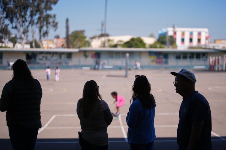 Teachers look on as students play on the playground at Perkins K-8 School in San Diego. The schools principal said he worries students are missing out on chances to learn how to show empathy, to share, to disagree, to understand each other.