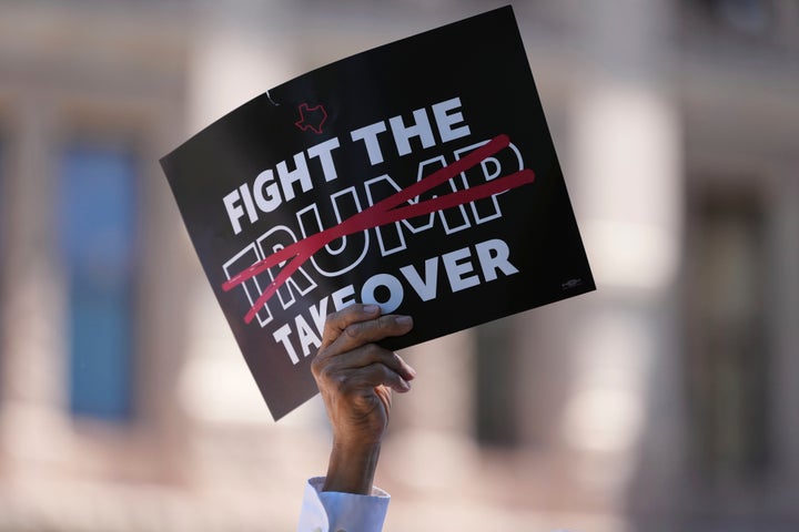 A demonstrator holds a sign during a rally against redistricting in Austin, Texas. 