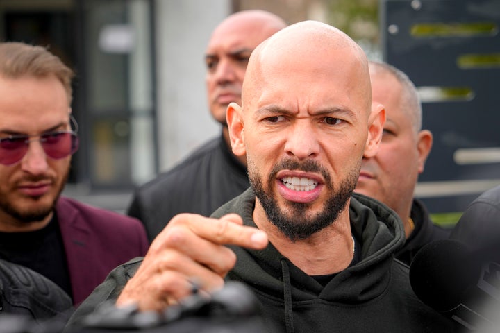 Andrew Tate gestures while speaking to media after checking in at a police station as part of his judicial control, which requires him to appear before judicial authorities in Romania when summoned, after returning from the United States, in Voluntari, Romania, Monday, March 24, 2025. (AP Photo/Vadim Ghirda)