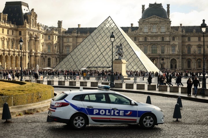 A police car parks in the courtyard of the Louvre museum, one week after the robbery, on Oct. 26, 2025, in Paris. (AP Photo/Thomas Padilla, File)