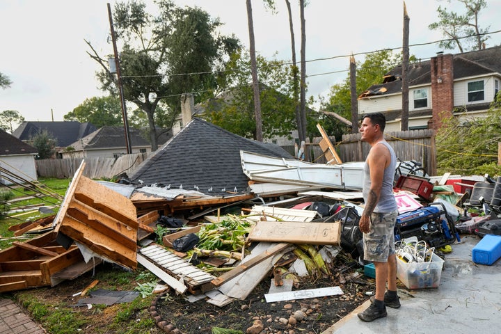 Jose Rosas surveys damage to Guillermo Vargas' home as while helping clean up storm damage in the Memorial Northwest subdivision, in Spring, Texas, Monday, Nov. 24, 2025.