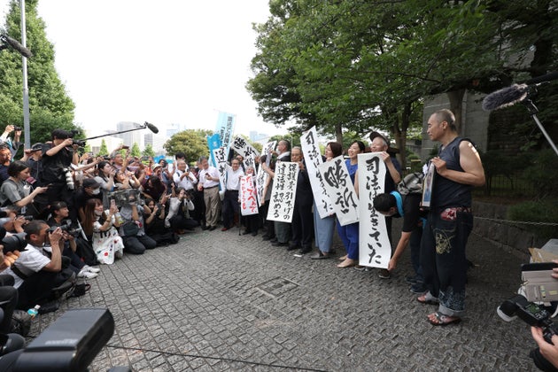生活保護訴訟／「勝訴」などと書かれた紙を掲げる原告団ら