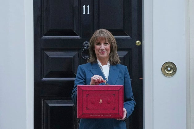Chancellor Rachel Reeves poses on the doorstep of 11 Downing Street with her ministerial red box before heading to the House of Commons to deliver her Budget speech in London, Wednesday, Nov. 26, 2025.