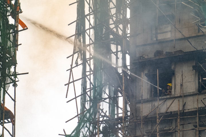 A firefighter tries to extinguish a fire at Wang Fuk Court, a residential neighborhood in the Tai Po district of Hong Kong's New Territories on November 27, 2025.