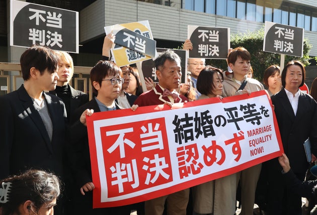 判決後「不当判決」の旗を手にする原告ら