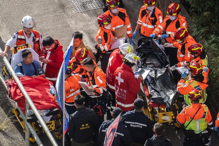 Health workers remove a body after a deadly fire Wednesday at Wang Fuk Court, a residential estate in the Tai Po district of Hong Kong's New Territories, on Nov. 28, 2025.