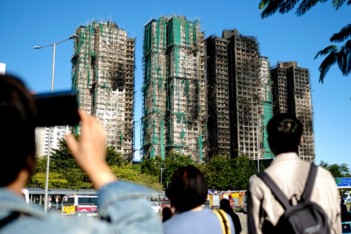 Lethal Hong Kong Excessive-Rise Hearth Raises Questions About Corruption And Negligence 3 People take photos of Wang Fuk Court the deadly high-rise apartment fire on November 29, 2025 in Hong Kong, China. (Photo by Sawayasu Tsuji/Getty Images)