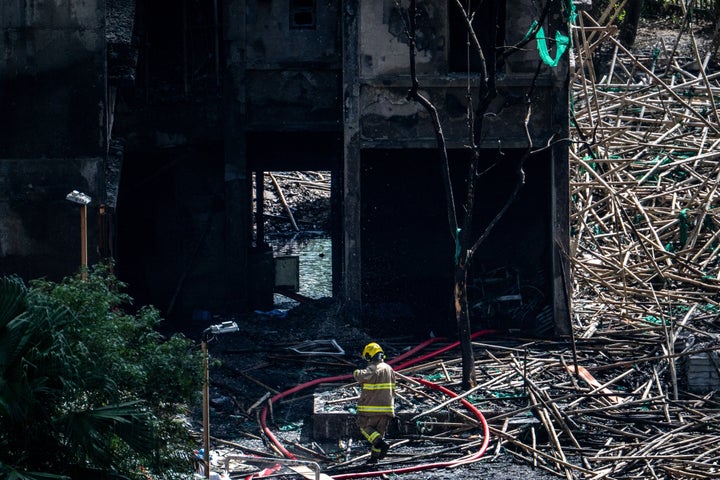 A firefighter works outside one of the housing blocks of Wang Fuk Court in the aftermath of the deadly November 26 fire, in Hong Kong on November 29, 2025. (Photo by Philip FONG / AFP via Getty Images)