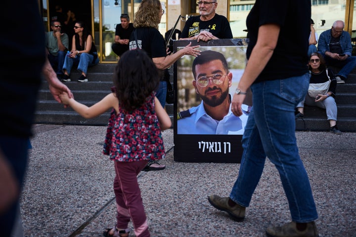 A man in Tel Aviv holds a poster with a photo of Israeli hostage Ran Gvili during a rally calling for the return of his remains, on Dec. 5, 2025. Hamas has held Gvili's body in Gaza since he was killed in the Oct. 7, 2023 attack.
