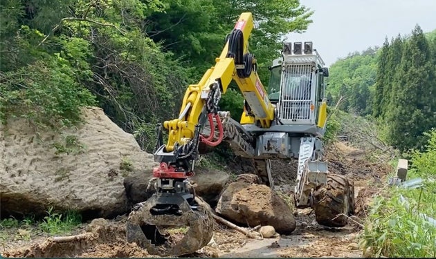 巨大な落石を跨いで前進するスパイダー＝石川県珠洲市