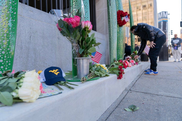 A person places flowers on a makeshift memorial Saturday, Nov. 29, 2025, outside of the Farragut West Station, near the site where two National Guard members were shot in Washington. (AP Photo/Jose Luis Magana)