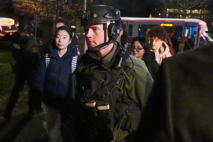 Students are escorted by law enforcement officers to a building at Brown University after a shooting, Saturday, Dec. 13, 2025, in Providence, R.I.. (AP Photo/Charles Krupa)