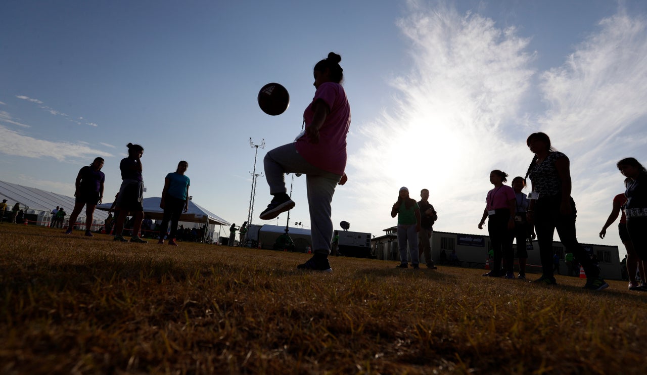 In this July 9, 2019, photo, immigrants play soccer at a U.S. government holding center for migrant children in Carrizo Springs, Texas. (AP Photo/Eric Gay)