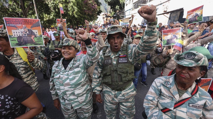 CARACAS, VENEZUELA - DECEMBER 13: Supporters of President Nicolas Maduro and members of the Bolivarian Civil Militia participate in a protest against the United States with banners reading "No more war for oil" in the working-class neighborhood of Petare, Caracas, Venezuela on December 13, 2025.