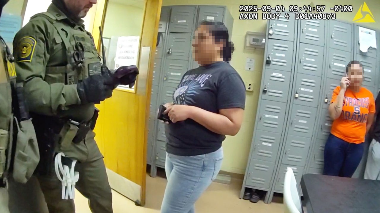 A federal agent questions a woman in the break room at Nutrition Bar Confectioners in Cato, New York, on Sept. 4, 2025.