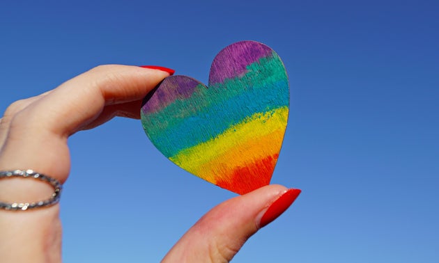 Person holding rainbow love heart.