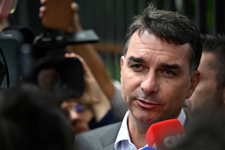 Senator Flavio Bolsonaro, son of former Brazilian president Jair Bolsonaro, speaks with journalists after leaving the Federal Police headquarters where his father is being held, in Brasilia, on Dec. 9, 2025.
