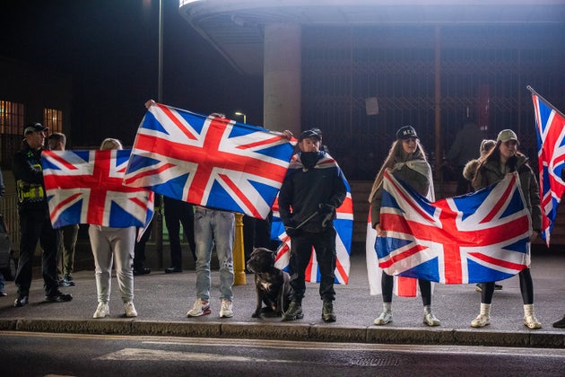 Far-right protesters hold flags outside the Dreamland Amusement Park during the rally. 