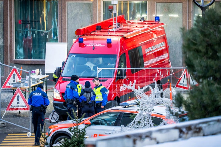 Police officers and rescuers stand next to a firefighter's vehicle on the site of a fire that ripped through the bar Le Constellation in Crans-Montana on January 1, 2026. (Photo by MAXIME SCHMID / AFP via Getty Images)