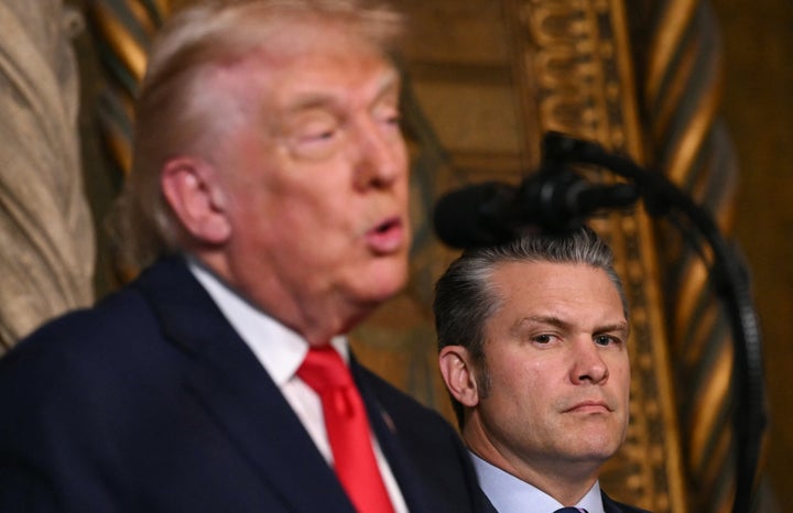 US Secretary of Defense Pete Hegseth listens to President Donald Trump announcing the US Navy's new Golden Fleet initiative, unveiling a new class of warships, at Mar-a-Lago in Palm Beach, Florida, on December 22, 2025. (Photo by ANDREW CABALLERO-REYNOLDS / AFP via Getty Images)