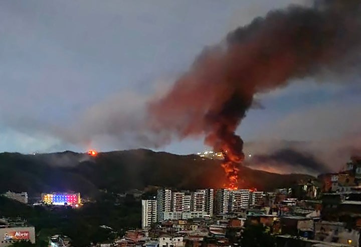 A ire at Fuerte Tiuna, Venezuela's largest military complex, is seen from a distance after a series of explosions in Caracas on January 3, 2026.