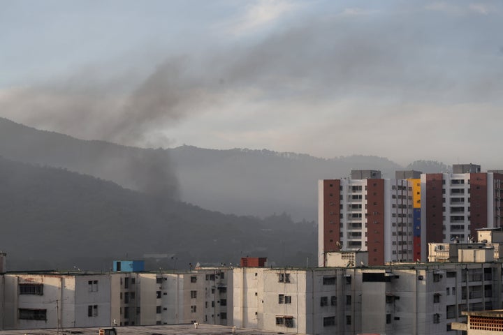 Smoke is seen over buildings after explosions and low-flying aircraft were heard on January 03, 2026 in Caracas, Venezuela.