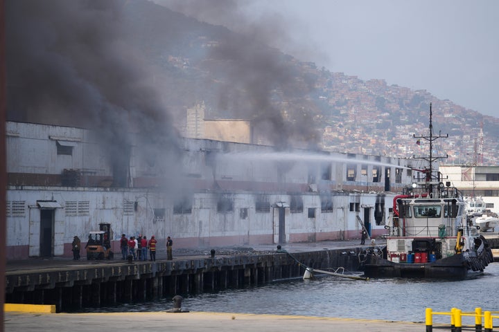 Smoke rises from a dock after explosions were heard at La Guaira port, Venezuela, Saturday, Jan. 3, 2026. (AP Photo/Matias Delacroix)
