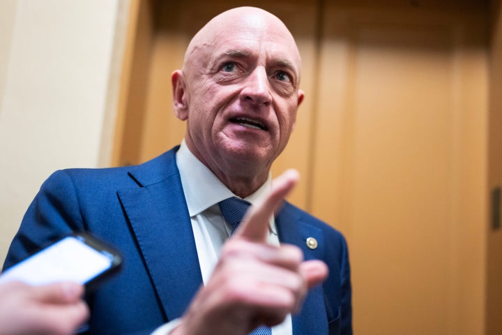 Sen. Mark Kelly (D-Ariz.) talks with reporters in the Senate subway on Tuesday, December 9, 2025.