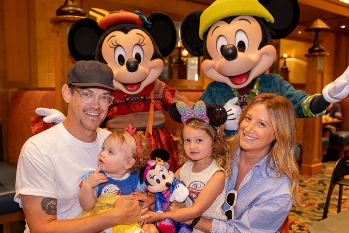 Ashley Tisdale (right) and her family pose with Mickey Mouse and Minnie Mouse while dining at Storytellers Cafe on September 3, 2025 in Anaheim, California.