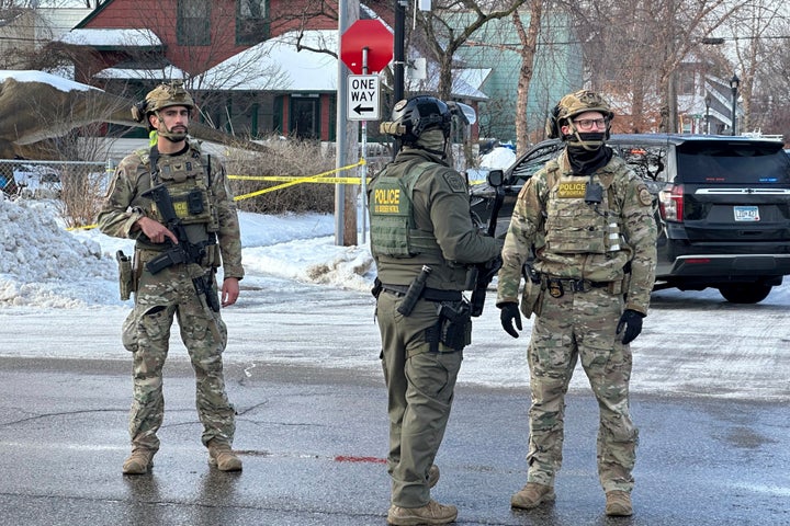 Federal law enforcement officers stand near a roadblock at Portland Avenue and East 32nd Street, Wednesday, Jan. 7, 2026, after reports of a shooting involving federal agents in Minneapolis, where immigration enforcement has been conducting a major crackdown. (AP Photo/Tim Sullivan)
