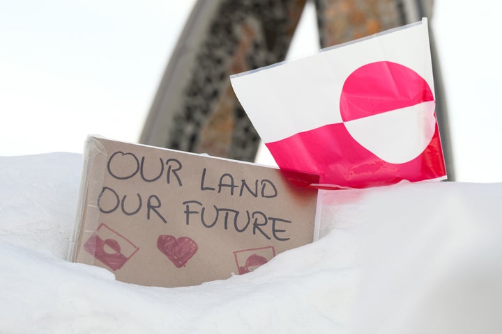 NUUK, GREENLAND - MARCH 30: A sign reading "Our Land Our Future" rests in the snow alongside the flag of Greenland, on March 30, 2025 in Nuuk, Greenland. A visit this week to Greenland by a US delegation - including Vice President JD Vance, his wife and other officials - has provoked angry reactions from politicians here and in Denmark, which governs the foreign and defense policies of the semiautonomous island. The American delegation's visit follows vows by US President Donald Trump to gain control of Greenland "one way or the other," citing its strategic importance to the US. (Photo by Leon Neal/Getty Images)