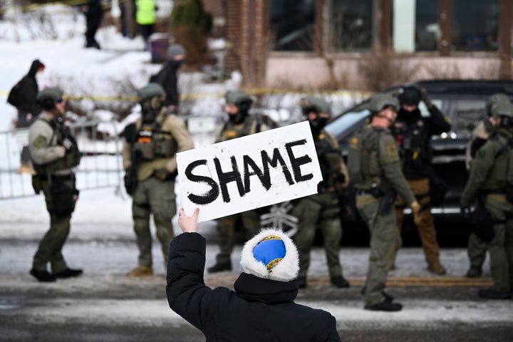 A spectator holds a sign that says 