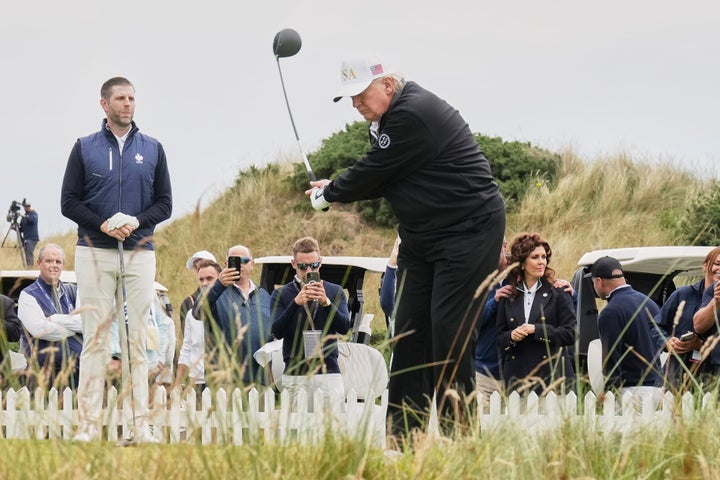 President Donald Trump tees off as Eric Trump, left, stands by during the opening ceremony for the Trump International Golf Links golf course, near Aberdeen, Scotland, Tuesday, July 29, 2025. (AP Photo/Jacquelyn Martin)
