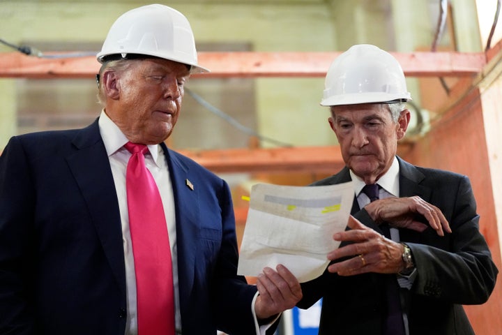 Federal Reserve Chairman Jerome Powell, right, and President Donald Trump look over a document of cost figures during a visit to the Federal Reserve, Thursday, July 24, 2025, in Washington.