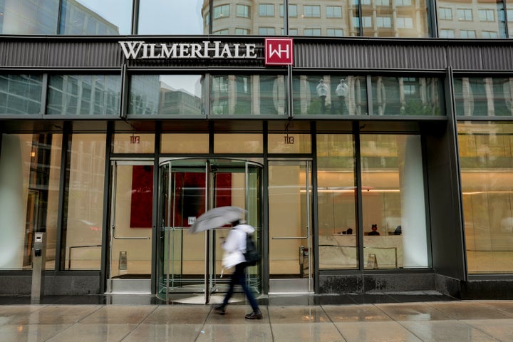 A person walks by the office building that houses WilmerHale law firm in Washington, D.C. A federal judge struck down an executive order by Trump targeting WilmerHale.