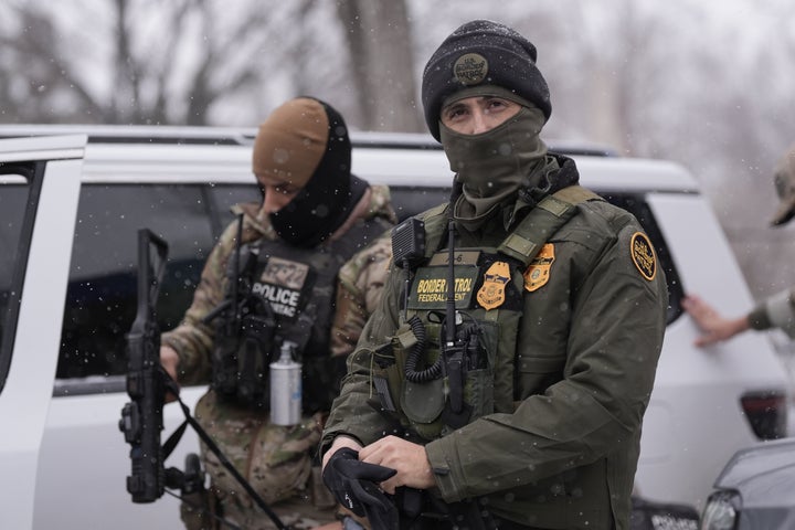 Federal agents stand outside a convenience store on Wednesday, Jan. 21, 2026, in Minneapolis. (AP Photo/Angelina Katsanis)