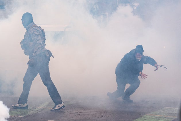 A man arrested by federal agents moments prior escapes in handcuffs after tear gas went off, Jan. 21, in Minneapolis.