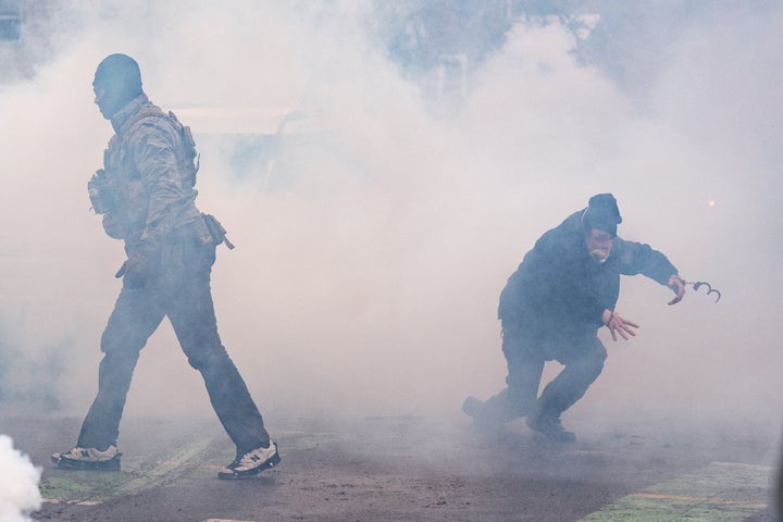 A man arrested by federal agents moments prior escapes in handcuffs after tear gas went off, Jan. 21, in Minneapolis.