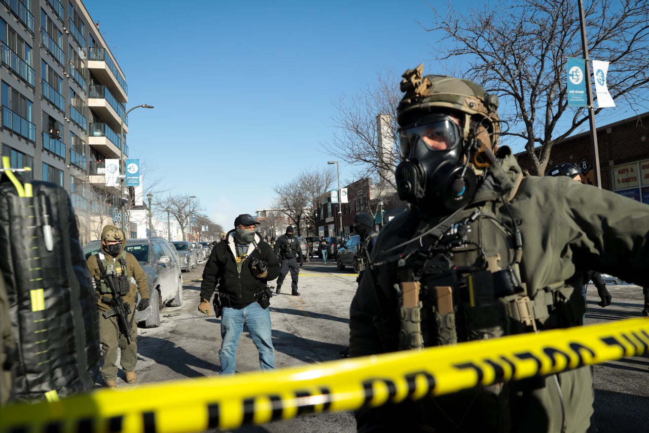 Federal agents establish a perimeter behind police tape as the crowd grows during demonstrations after the killing of Pretti in Minneapolis on Saturday.