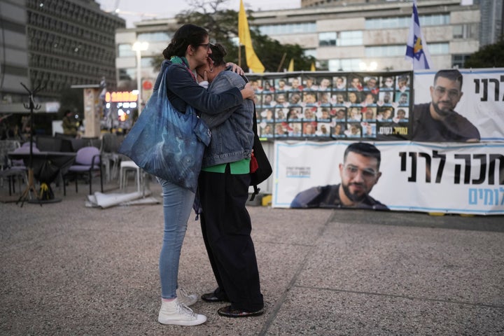 Two women embrace next to a banner of Ran Gvili after Israel announced that it recovered the last hostage's remains in Gaza, at Hostages Square plaza in Tel Aviv, on Jan. 26, 2026.