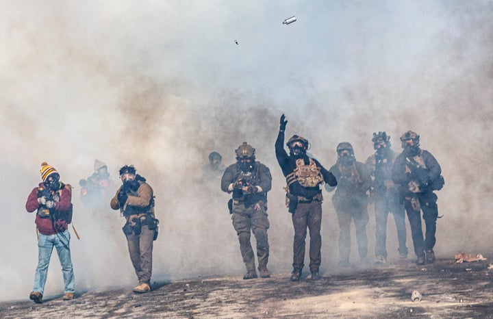 A federal agent lobs a teargas canister towards protesters as agents advance through clouds of tear gas during clashes following the fatal shooting of Alex Pretti earlier in the day, on Jan. 24 in Minneapolis.