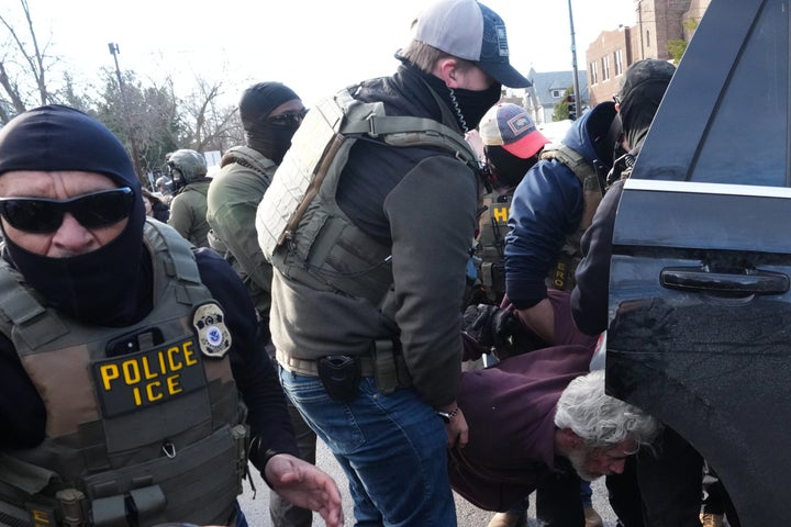 A protester is detained by federal agents near the site where Renee Good was shot and killed by an ICE officer last week, on January 13, 2026, in Minneapolis.
