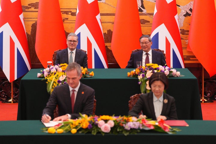 Britain's Prime Minister Keir Starmer and Chinese Premier Li Qiang (back-R) look on as Britain's Business Secretary Peter Kyle and Chinese Secretary of CPC Committee of the General Administration of Customs Sun Meijun sign a Memorandum of Understanding following a bilateral meeting at the Great Hall of the People in Beijing on January 29, 2026. (Photo by Carl Court / POOL / AFP via Getty Images)