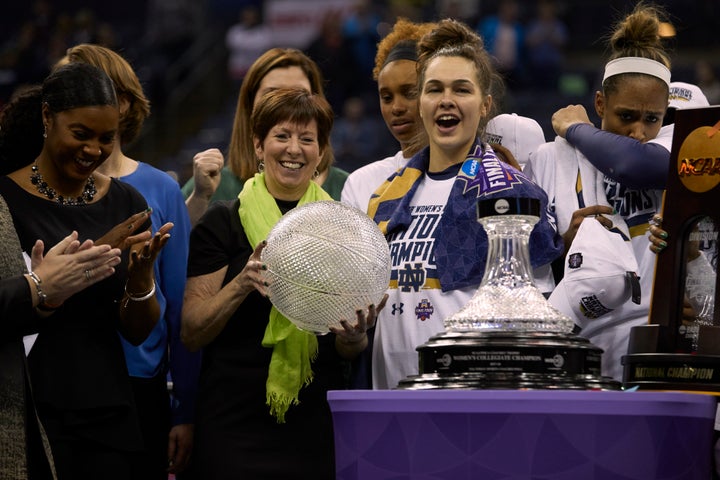 Notre Dame coach Muffet McGraw, holding the ball trophy, celebrates her team's national championship in 2018.