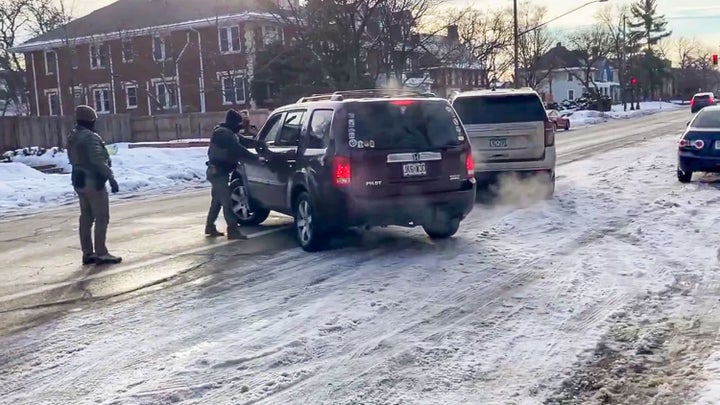 A still from a video showing the moments leading up the shooting of Renee Good, where Good is backing away from officers before she tries to pull away in her vehicle.