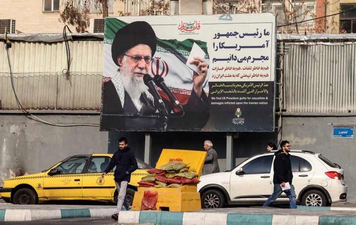 Iranians walk past a billboard showing Iranian supreme leader Ayatollah Ali Khamenei with anti-U.S. rhetoric in Tehran on Jan. 27.